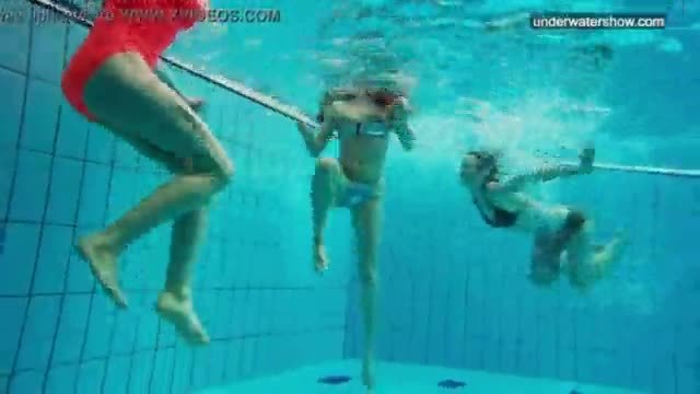 Three nude girls have fun underwater