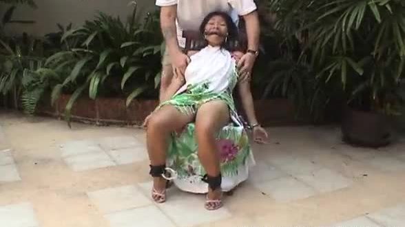 Asian teen tied up and hand cuffed on a chair